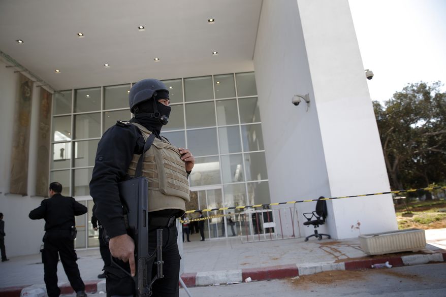 Policemen guard the entrance of the Bardo museum in Tunis, Tunisia, Thursday, March 19, 2015, as a a blood stain is seen at right, a day after gunmen opened fire killing over 20 people, mainly tourists. (AP Photo/Christophe Ena)