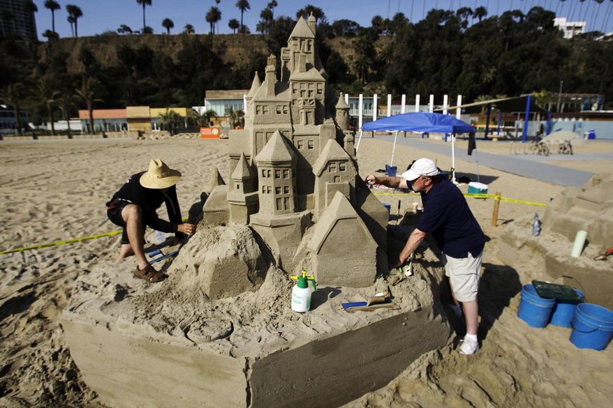 In this April 24, 2009, file photo, architects Greg Lebon, left, and Kent Trollen sculpt a sand castle on the beach during a preview tour of the Annenberg Community Beach House in Santa Monica, Calif. Santa Monica, a sun-splashed beach city of 92,000 people not only has a famous funky old pier and miles of beautiful beaches but enough museums, art galleries, historic landmarks, and chic shopping districts to rival even that giant metropolis to its east. (AP Photo/Reed Saxon, File)