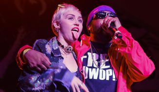 Miley Cyrus, left, joins Mike Will Made It onstage at the Fader Fort Presented by Converse during the SXSW Music Festival on Thursday, March 19, 2015 in Austin, Texas. (Photo by Jack Plunkett/Invision/AP)