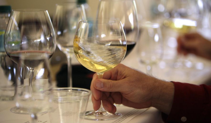 File - In this May 20, 2009 file photo a glass of white wine is swirled during a tasting in Oakville, Calif. More than two dozen California vintners are facing a lawsuit claiming their wines contain dangerously high levels of arsenic. The industry group Wine Institute dismissed the allegations as "false and misleading." (AP Photo/Eric Risberg, File)