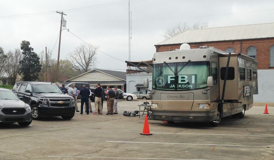 FBI agents meet outside a portable command post in Port Gibson, Miss., as they continue their investigation into the circumstances surrounding the hanging death of Otis Byrd, an ex-convict reported missing by his family more than two weeks ago, Friday, March 20, 2015. (AP Photo/Jeff Amy)