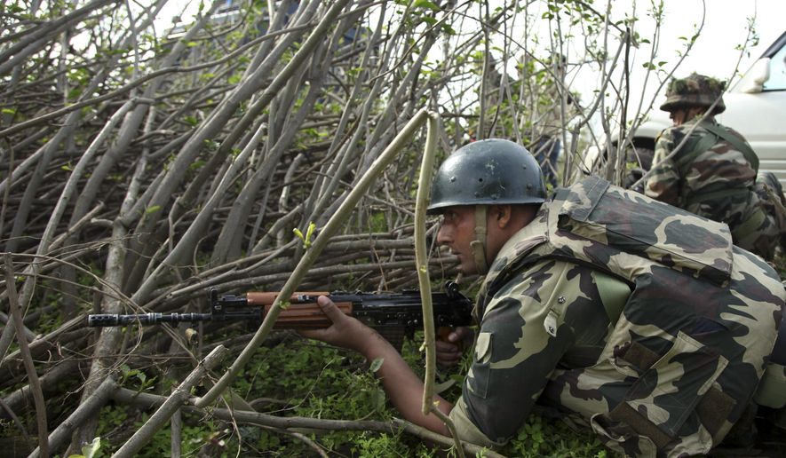 Indian paramilitary soldiers take position as they watch a gun battle between suspected militants and security forces in Kathua district, about 80 kilometers (50 miles) south of Jammu, India, Friday, March 20, 2015. Suspected rebels wearing army uniforms stormed an Indian police station in Kashmir, sparking a four-hour gun battle near the border between Indian- and Pakistani-controlled parts of the disputed Himalayan region. (AP Photo/Channi Anand)