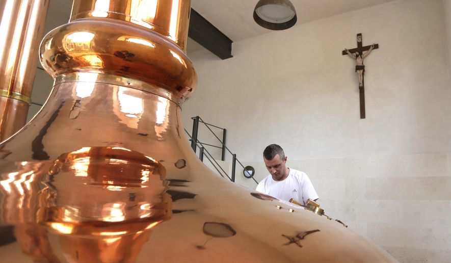 In this photo taken Wednesday, March 18, 2015, a worker at Cvikov Brewery adds hops to a beer tank in Cvikov, Czech Republic. After shutting down in droves during the decades of Communist rule, the Czech Republic’s small brewers are staging a comeback. Dilapidated beer making facilities dotted across this patch of Central Europe, which is better known for a clutch of global brands like Pilsner Urquell, are being reopened to revive local brewing traditions that date back to the 10th century. (AP Photo/Petr David Josek)