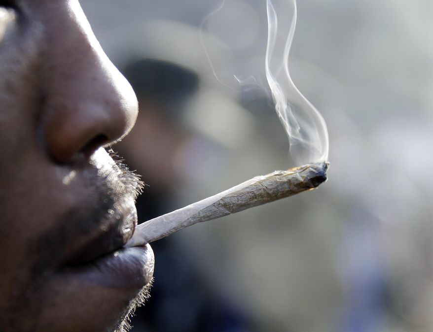 A man smokes a marijuana cigarette as a large group gathered near the New Jersey Statehouse to show their support for legalizing marijuana Saturday, March 21, 2015, in Trenton, N.J. The event drew a diverse crowd of roughly 200 people. Many said they wanted to show their support for legalizing or decriminalizing pot, while others said it should only be given to people with medical conditions that could be eased by the drug. Several people were openly smoking the drug during Saturday's rally, but apparently none were arrested. (AP Photo/Mel Evans)