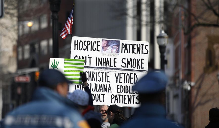 New Jersey State Police watch as several people hold signs during a large gathering near the New Jersey Statehouse to show their support for legalizing marijuana Saturday, March 21, 2015, in Trenton, N.J. (AP Photo/Mel Evans) **FILE**