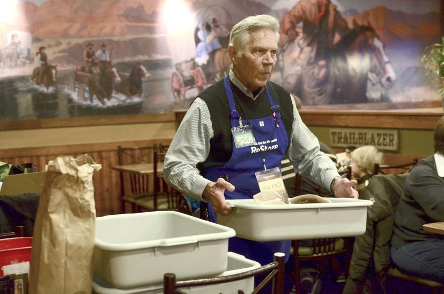 FOR RELEASE SUNDAY, MARCH 22, 2015, AT 12:01 A.M. CDT.- Howard Hartman, executive director for Twin Rivers Habitat for Humanity and director for ReStore, takes dirty dishes back to the kitchen at Pizza Ranch in Fort Dodge, Iowa, to be washed. Hartman and several other volunteers bussed tables at Pizza Ranch in February to raise funds for Habitat. (AP Photo/The Messenger, Jesse Major)