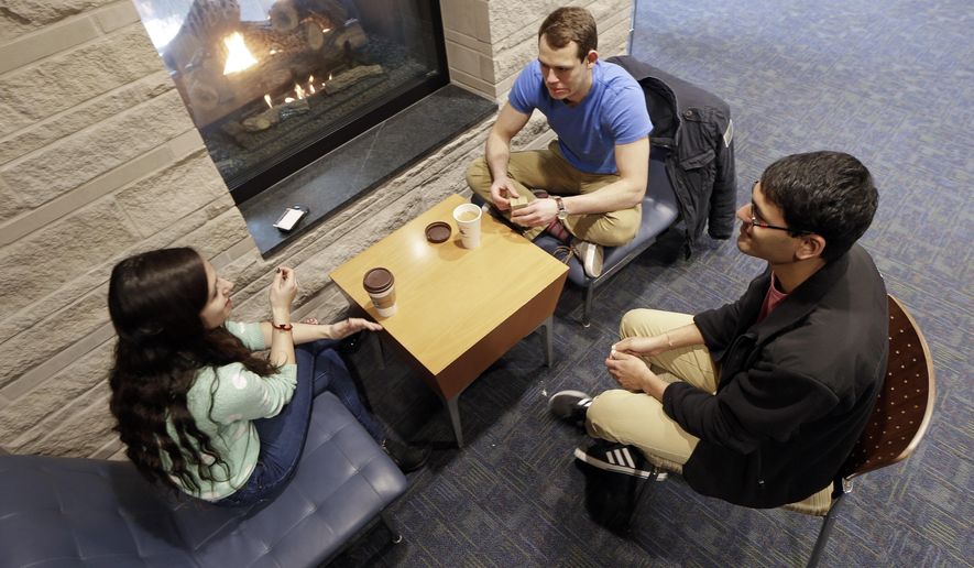 In this Feb. 24, 2015 photo, Vivek Shah, right, a sophomore resident advisor at Vanderbilt University, talks with friends Samara Lieberman, left, a senior from Detroit, and Tyler Shull, center, a sophomore from Chapel Hill, NC, by a fireplace in the great room in the Warren College and Moore College section of the Vanderbilt campus in Nashville, Tenn. Vanderbilt is one of a small but growing number of U.S. colleges and universities that have embraced a "residential college" model where students become part of a close-knit but diverse community that enhances both their academic and social lives. (AP Photo/Mark Humphrey)