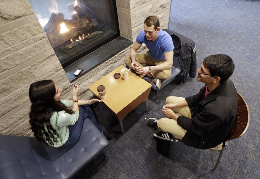 In this Feb. 24, 2015 photo, Vivek Shah, right, a sophomore resident advisor at Vanderbilt University, talks with friends Samara Lieberman, left, a senior from Detroit, and Tyler Shull, center, a sophomore from Chapel Hill, NC, by a fireplace in the great room in the Warren College and Moore College section of the Vanderbilt campus in Nashville, Tenn. Vanderbilt is one of a small but growing number of U.S. colleges and universities that have embraced a "residential college" model where students become part of a close-knit but diverse community that enhances both their academic and social lives. (AP Photo/Mark Humphrey)