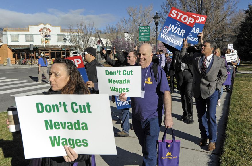 FILE - In this March 12, 2015, file photo, about 100 people rally in front of the Nevada Legislative Building and Capitol in Carson City, Nev. People at the event, organized by the AFL-CIO, were protesting what they say is a constant attack on workers since Republicans took control of the Nevada Legislature. At a rally a week later, a woman yelled to a crowd of union workers in front of the Nevada Capitol, screaming until her voice broke for the governor to "quit attacking us" and rallying attendees to "stand up, fight back!" But Gov. Brian Sandoval didn't come out, and a bevy of bills to weaken collective bargaining and restructure public employee pensions remain on the agendas--including one scheduled for a hearing Wednesday, March 25, that labor groups call the "Union Armageddon Bill." (AP Photo/Lisa J. Tolda, File).