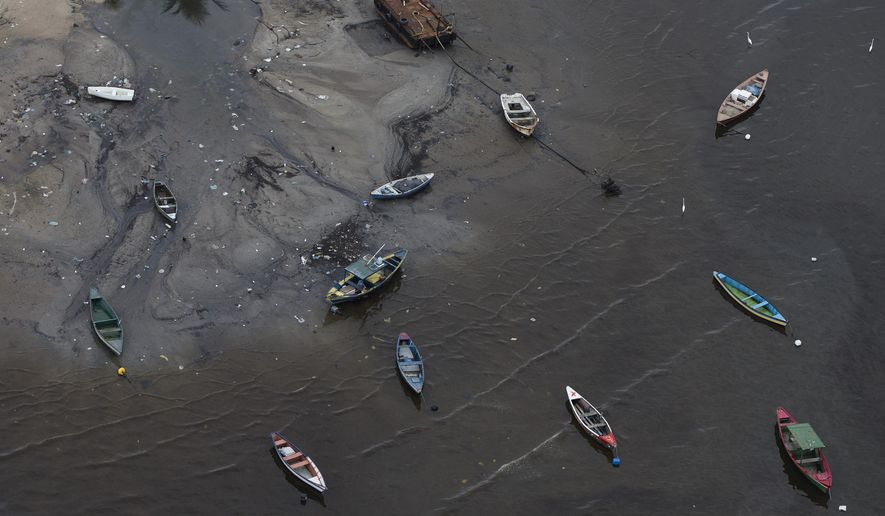 Small boats sit on the shore of Guanabara Bay near the suburb of Sao Goncalo, across the bay from Rio de Janeiro, Brazil, Monday, March 23, 2015. Authorities promised in Rio’s winning bid to drastically clean up the pollution in Guanabara bay, cutting it by 80 percent. But with 500 days left before the games, experts say efforts have had little impact on the garbage and sewage pollution of the waters where sailing, swimming and other aquatic events will take place. (AP Photo/Felipe Dana)