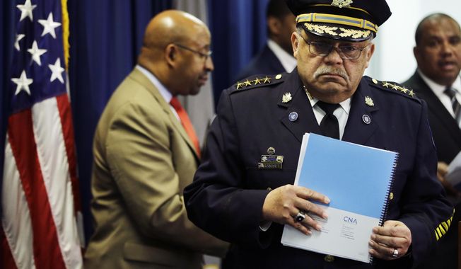 Philadelphia Police Commissioner Charles Ramsey holds a newly released report during a news conference Monday, March 23, 2015, in Philadelphia. Poor training has left Philadelphia police officers with the mistaken belief that fearing for their lives alone is justification for using deadly force, the Justice Department said Monday in a review of the city’s nearly 400 officer-involved shootings since 2007.  (AP Photo/Matt Rourke)