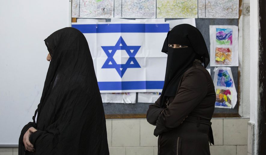 FILE - In this Tuesday, March 17, 2015 file photo, Bedouin women wait to cast their votes at a polling station in the town of Rahat, Israel on for parliament elections. After a strong performance in last week&amp;#8217;s parliamentary election, Prime Minister Benjamin Netanyahu seems to be cruising toward forming a new government of hardline and religious parties. But in the smoke-and-mirrors world of Israeli politics, a centrist government more amenable to peace negotiations could easily emerge at the last minute instead. (AP Photo/Tsafrir Abayov, File)