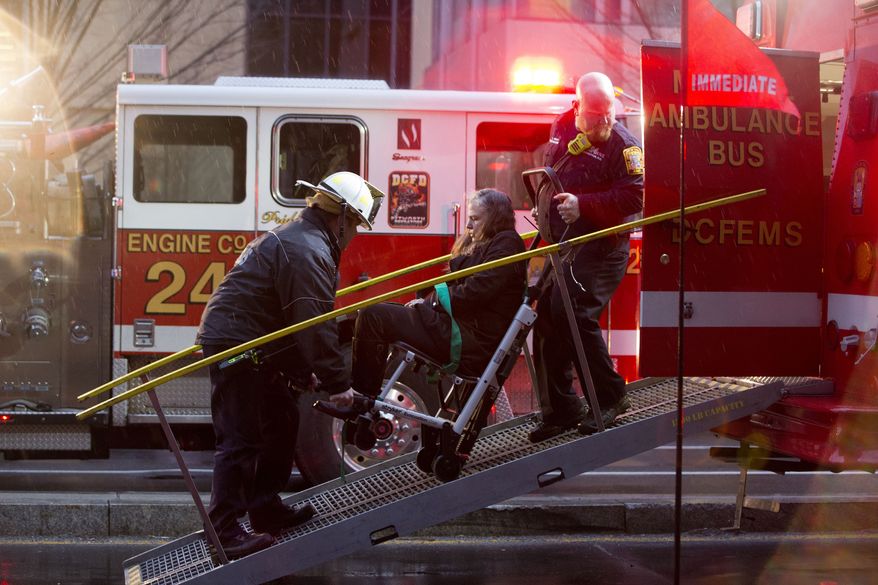In this Jan. 12, 2015 file photo, a woman is transported in a wheelchair onto an ambulance as people are evacuated from a smoke filled Metro subway tunnel in Washington. A policy of routing calls about emergencies on the Metro subway system directly to a supervisor at the District of Columbia&amp;#8217;s 911 call center contributed to delays in getting firefighters to the scene of an accident that turned deadly, officials say. (AP Photo/Jacquelyn Martin, File) — FILE