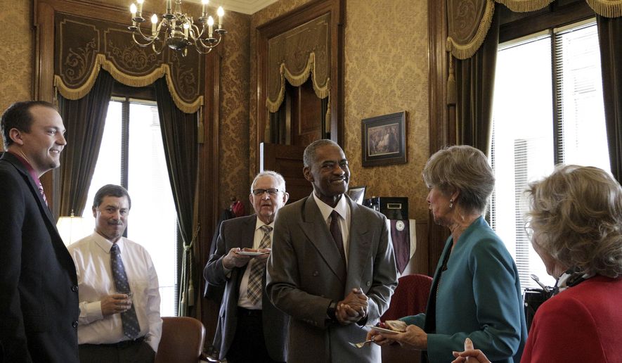 Washington State University President Elson Floyd, center, meets with lawmakers following the passage of a bill that opens the door for the college to open a medical school in Spokane, Wash., on Wednesday, March 25, 2015, in Olympia, Wash. The bill eliminates a restriction dating from 1917 that gives the University of Washington in Seattle the exclusive right to operate a public medical school in the state.(AP Photo/Rachel La Corte)