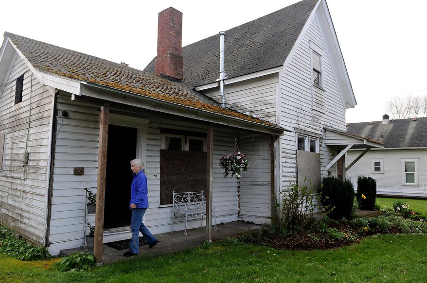Homeowner Patricia Benner strolls along the outside of the Gorman House, which is the oldest existing residence in Oregon directly tied to early black pioneers, in Corvallis, Ore., on Tuesday, March 17, 2015. (AP Photo/The Gazette-Times, Amanda Cowan)