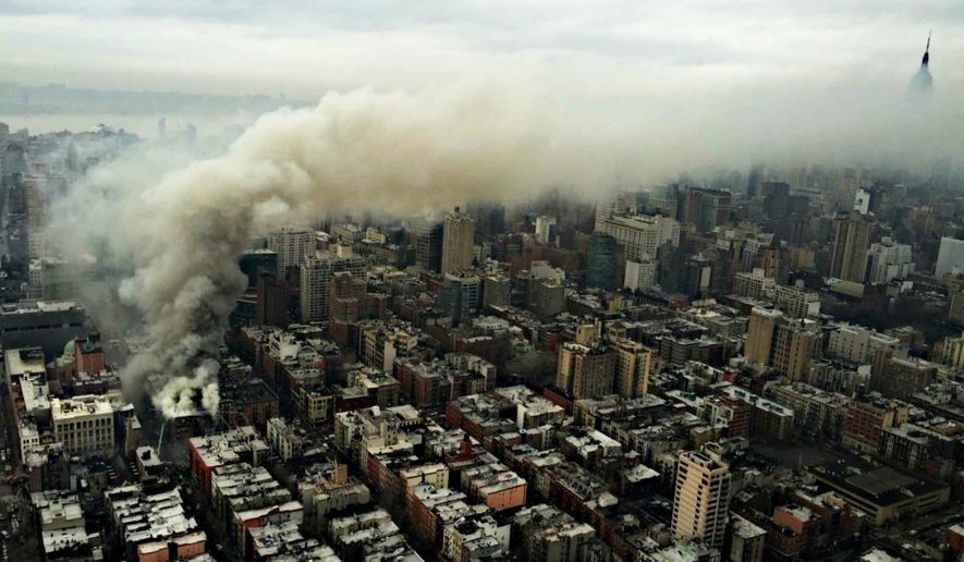 In this photo provided by the NYPD Special Ops, smoke rises from the scene of a large fire and a partial building collapse in the East Village neighborhood of New York on Thursday, March 26, 2015. Orange flames and black smoke are billowing from the facade and roof of the building near several New York University buildings. (AP Photo/NYPD Special Ops)