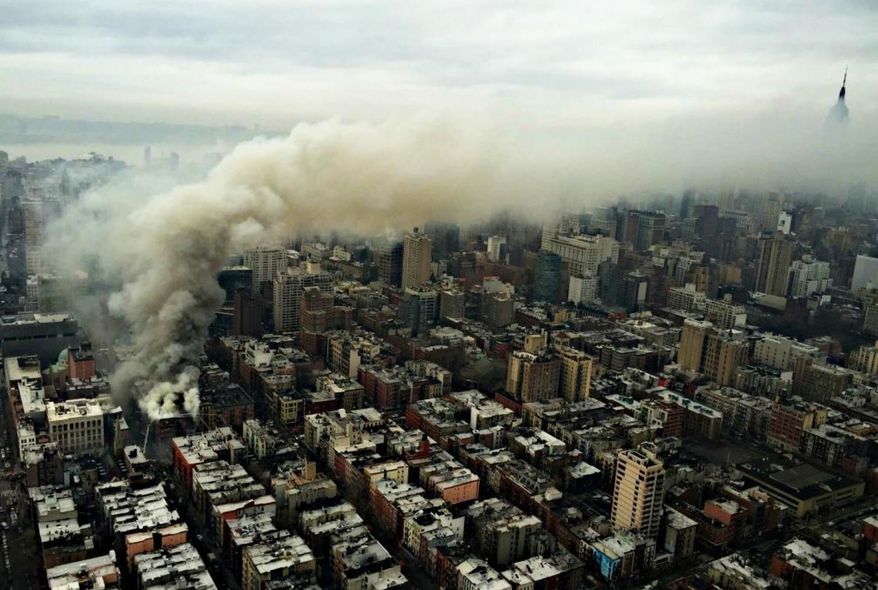 In this photo provided by the NYPD Special Ops, smoke rises from the scene of a large fire and a partial building collapse in the East Village neighborhood of New York on Thursday, March 26, 2015. Orange flames and black smoke are billowing from the facade and roof of the building near several New York University buildings. (AP Photo/NYPD Special Ops)