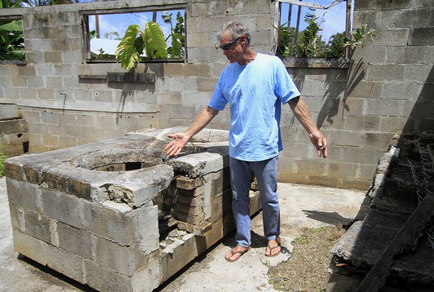 ADVANCE FOR SATURDAY MARCH 28 AND THEREAFTER This March 21, 2015 photo shows property owner Randall Brokaw as he looks at an old stove surface in a derelict kitchen structure at the site of the former Chee Kung Tong Society building in Wailuku, Hawaii. Brokaw knows the clock is ticking for a possibly century-old Chinese wall, with ties to the venerable Dr. Sun Yat-sen, before it is destroyed or crumbles away in old Wailuku town. (AP Photo/The Maui News, Chris Sugidono)