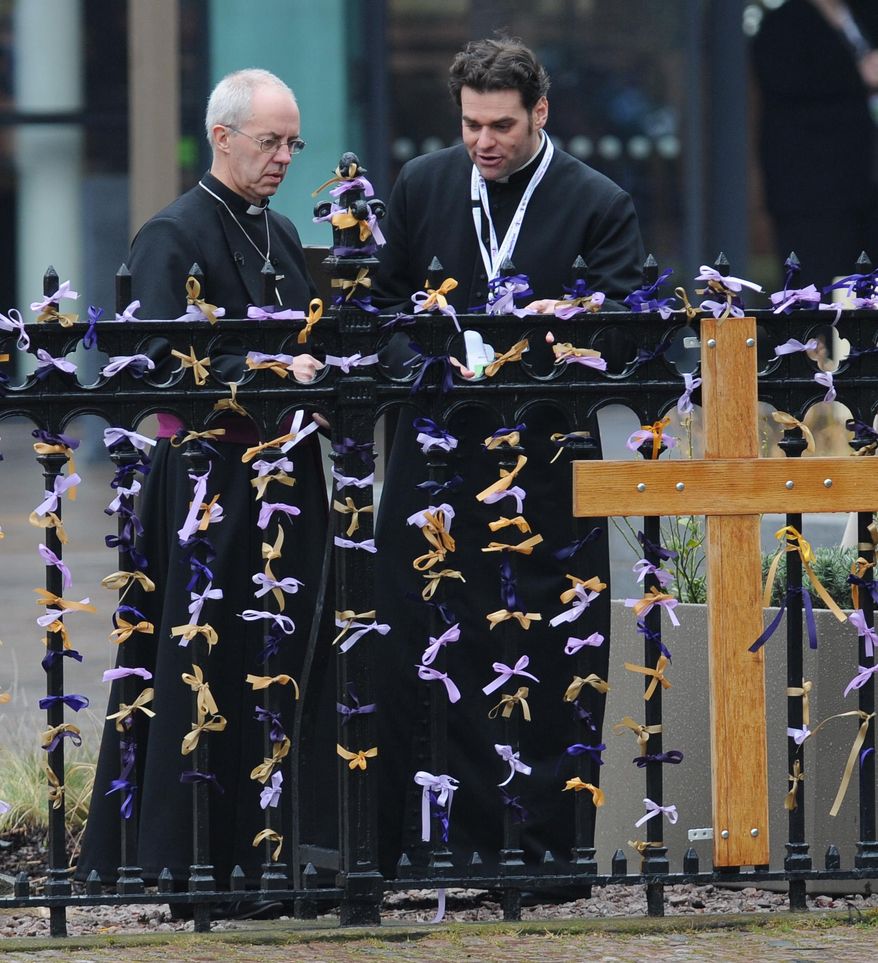 The Archbishop of Canterbury, Justin Welby, left, looks at pray ribbons outside Leicester Cathedral to attend a service for the re-reinterment of the mortal remains of Richard III at Leicester Cathedral, Leicester, England, Thursday, March 26, 2015. The skeleton of King Richard III was discovered in 2012 in the foundations of Greyfriars Church, Leicester, 500 years after he was killed in the Battle of Bosworth Field. (AP Photo/Rui Vieira)