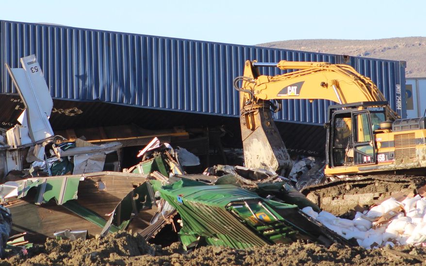 Union Pacific crews work Thursday, March 26, 2015, to clean up after 34 cars of a freight train derailed the day before about 22 miles north of Fallon, Nev. The derailment forced the closure of a stretch of U.S. Highway 95 for several hours for fear of a possible hazardous leak, but the crash site was declared safe and no injuries reported. (AP Photo/Lahontan Valley News, Steve Ranson)