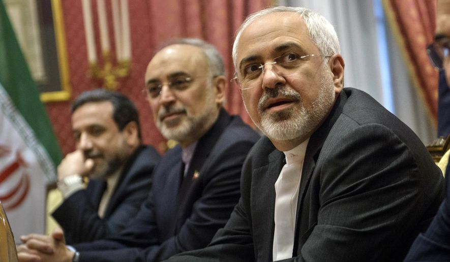 Iranian Foreign Mohammad Minister Javad Zarif, right, waits for the start of a meeting with a U.S. delegation at a hotel in Lausanne Switzerland on Thursday March 26, 2015, during negotiations on the Iranian nuclear program. (AP Photo/Brendan Smialowski)