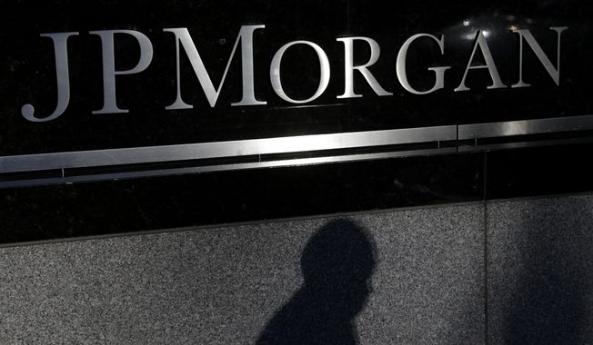 In this Nov. 19, 2013, file photo, the shadow of a pedestrian is cast under a sign in front of JPMorgan Chase &amp; Co. headquarters in New York. (AP Photo/Seth Wenig, File)