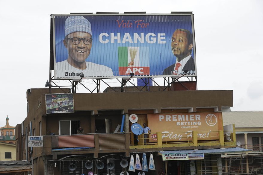 An electronic billboard with Opposition Presidential Candidate, Muhammadu Buhari, of the All Progressives Congress party, left, and his running mate, Yemi Osinbanjo is seen, in Oshodi neighborhood in Lagos, Nigeria, Thursday, March. 26, 2015. Nigeria goes to the polls Saturday to elect a new President. (AP Photo/Sunday Alamba)