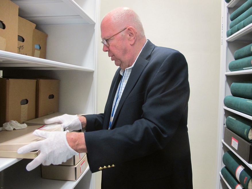 Charles Lesser, a retired archivist for the South Carolina Department of Archives and History and an expert on colonial documents, removes South Carolina's earliest government documents from a vault at the department in Columbia, S.C., on Friday, March 27, 2015. The documents were recently conserved in Massachusetts and returned to the state. (AP Photo/Bruce Smith)