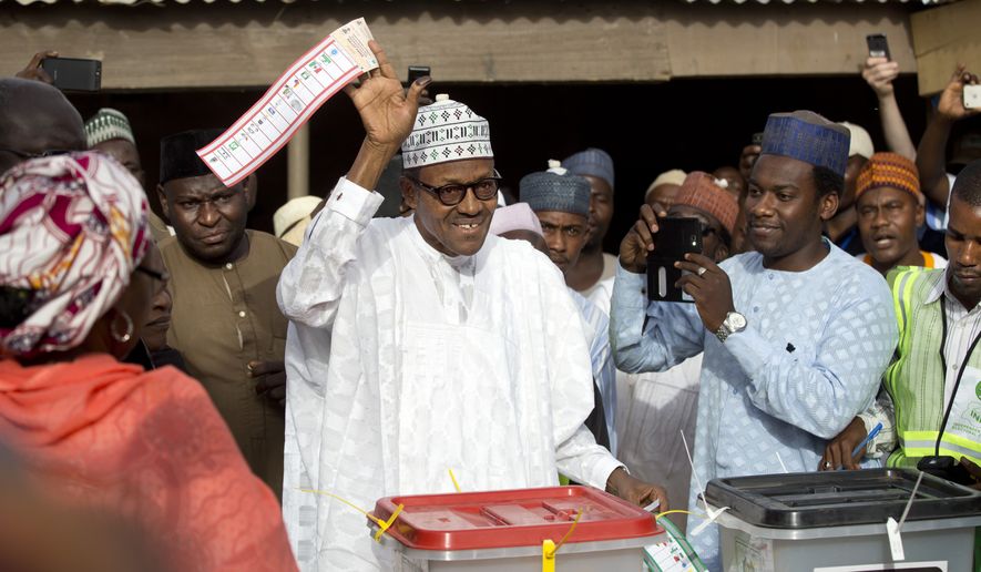 Opposition candidate Gen. Muhammadu Buhari holds his ballot paper in the air before casting his vote in his home town of Daura, northern Nigeria Saturday, March 28, 2015. Nigerians went to the polls Saturday in presidential elections which analysts say will be the most tightly contested in the history of Africa&#x27;s richest nation and its largest democracy. (AP Photo/Ben Curtis)