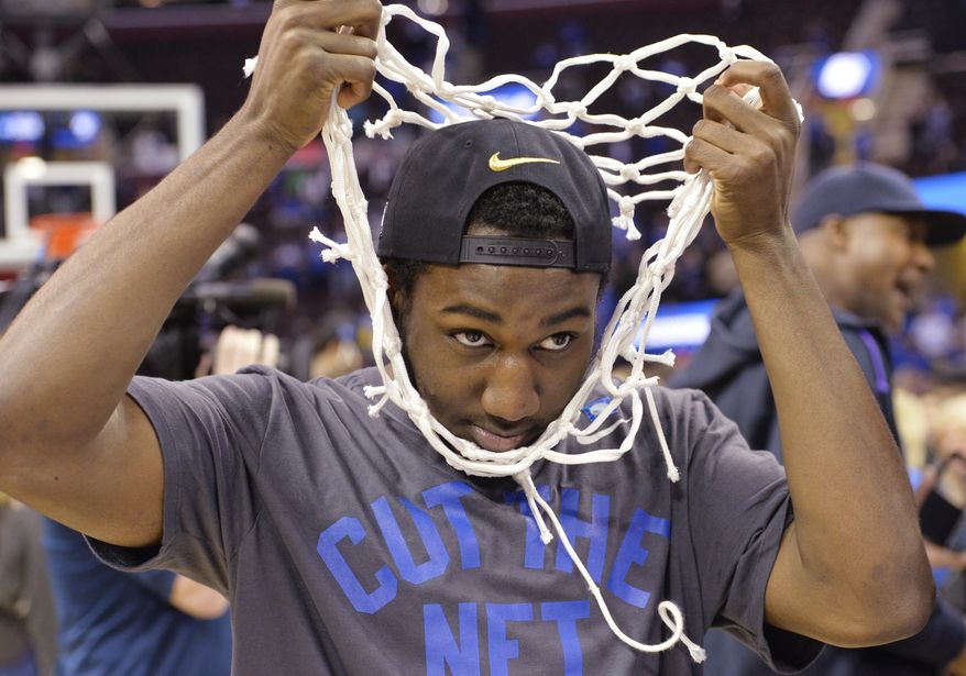 Kentucky's Dominique Hawkins pulls the net over his head during the celebration after Kentucky's 68-66 win over Notre Dame in a college basketball game in the NCAA men's tournament regional finals, Saturday, March 28, 2015, in Cleveland. Kentucky remains unbeaten and is headed for the Final Four ion Indianapolis. (AP Photo/David Richard)