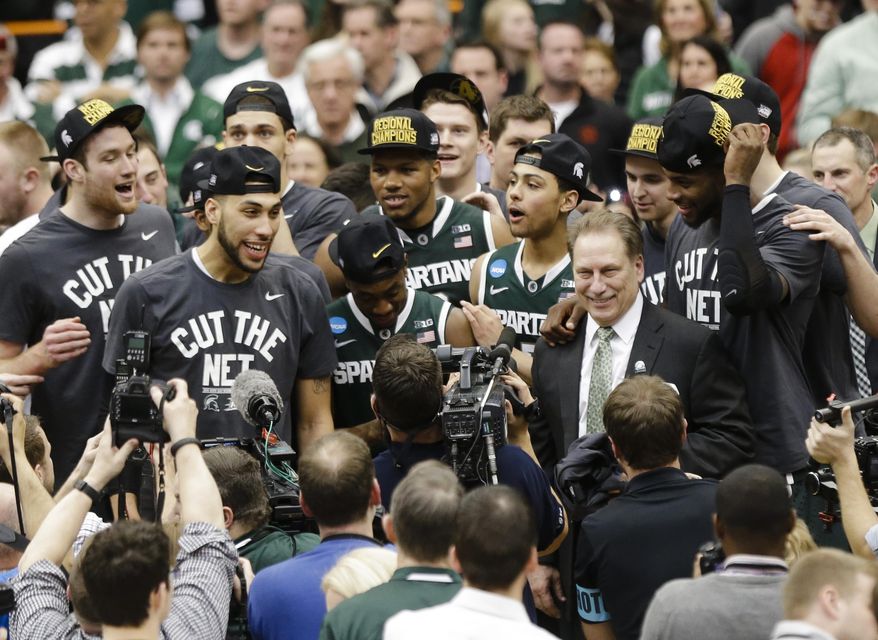 Michigan State coach Tom Izzo celebrates with his team after the East Regional final against Louisville in the NCAA men's college basketball tournament Sunday, March 29, 2015, in Syracuse, N.Y. Michigan State won 76-70. (AP Photo/Heather Ainsworth)