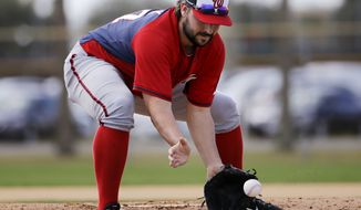 Washington Nationals pitcher Tanner Roark plays a ground ball during a drill at a spring training baseball workout, Sunday, Feb. 22, 2015, in Viera, Fla. (AP Photo/David Goldman)