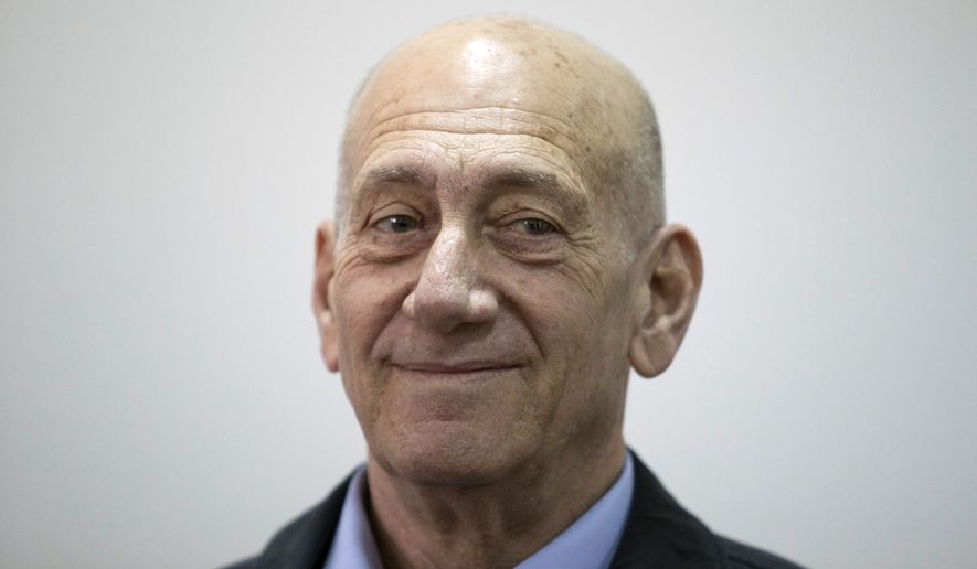 Former Israeli Prime Minister Ehud Olmert smiles as he waits in a court room in Jerusalem&#39;s District Court on Monday, March 30, 2015. The court later found Olmert guilty of accepting bribes in a retrial of corruption charges, (AP Photo/Abir Sultan, Pool)
