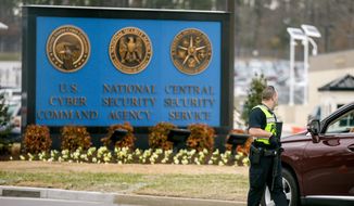 A police officer directs a vehicle to turn away at the National Security Agency, Monday, March 30, 2015, in Fort Meade, Md. Earlier, a firefight erupted when two men dressed as women tried to ram a car into a gate, killing one of them and wounding the other, officials said. (AP Photo/Andrew Harnik)