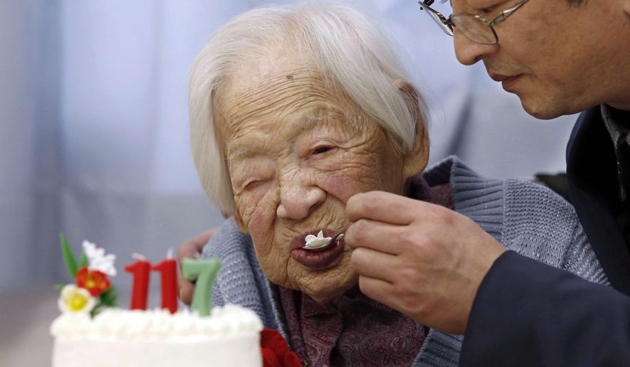FILE - In this March 5, 2015 file photo, Japan's Misao Okawa who is recognized as the world's oldest living person by Guinness World Records, eats cake, helped by her nursing home staff member, during her 117th birthday celebration event at a nursing home in Osaka, western Japan. Okawa died Wednesday, April 1, 2015, a few weeks after celebrating her 117th birthday. (AP Photo/Kyodo News, File) JAPAN OUT, MANDATORY CREDIT