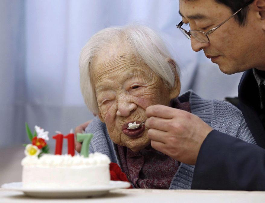 FILE - In this March 5, 2015 file photo, Japan's Misao Okawa who is recognized as the world's oldest living person by Guinness World Records, eats cake, helped by her nursing home staff member, during her 117th birthday celebration event at a nursing home in Osaka, western Japan. Okawa died Wednesday, April 1, 2015, a few weeks after celebrating her 117th birthday. (AP Photo/Kyodo News, File) JAPAN OUT, MANDATORY CREDIT