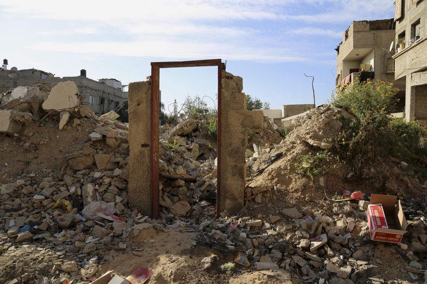 An empty frame doorway is seen standing on the rubble of a destroyed building that was damaged in last summer's Israel-Hamas war, without a door painting, presumably painted by British street graffiti artist Banksy, east of Jebaliya, in the northern Gaza Strip, Tuesday, March 31, 2015. Artworks by the elusive British graffiti artist Banksy are typically sold for hundreds of thousands of dollars, but in the Gaza Strip a local painter has succeeded in purchasing a Banksy original for less than $200. The popular street artist is believed to have sneaked into Gaza in February, leaving behind four murals including one drawn on a metal door that depicted a Greek goddess cowering against the rubble of a destroyed house. The painting of the goddess Niobe, titled "Bomb Damage," was drawn on the lone remaining part of a two-story house belonging to the Dardouna family in Jabaliya, northern Gaza Strip. (AP Photo/Adel Hana)
