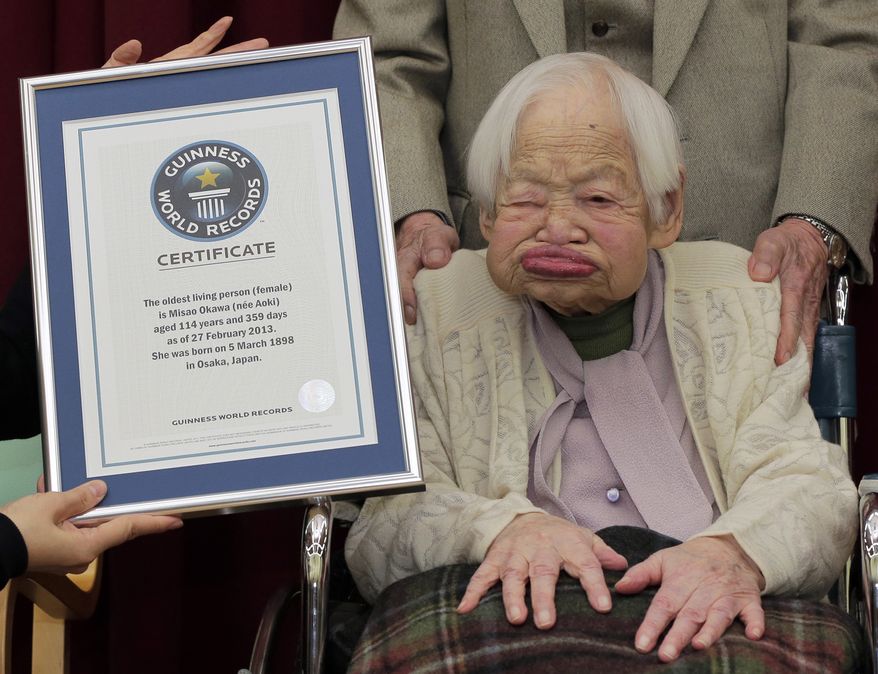 In this Feb. 27, 2013, file photo, Japan's Misao Okawa, then 114, poses with the certificate of the world's oldest woman, which was presented to her by Guinness World Records Japan Country Manager Erika Ogawa, unseen, at a nursing home in Osaka, western Japan. The world's oldest person has died nearly a month after celebrating her 117th birthday. Her nursing home says Misao Okawa died of heart failure early Wednesday, April 1, 2015. (AP Photo/Itsuo Inouye, File)