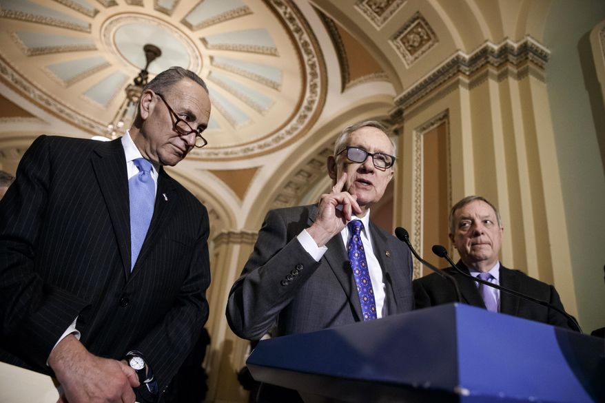FILE - In this March 3, 2015 file photo, Senate Minority Leader Harry Reid of Nev., center, flanked by Sen. Charles Schumer, D-N.Y., left, and Senate Minority Whip Richard Durbin of Ill., speaks during a news conference on Capitol Hill in Washington. In the wake of the announced retirement of Reid, a very public feud has opened between the No. 2 and No. 3 Senate Democrats and former long-time housemates, Schumer and Durbin. (AP Photo/J. Scott Applewhite, File)