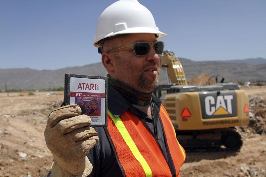 FILE - In this April 26, 2014 file photo, film director Zak Penn shows a box of a decades-old Atari "E.T. the Extra-Terrestrial" game found in a dumpsite in Alamogordo, N.M. A documentary on Atari's decline and a decades-old urban legend on the secret dumping of the "E.T." game in the New Mexico desert is airing on Netflix. "Atari: Game Over" was released on the streaming service late Wednesday, April 1, 2015, and details the demise of gaming giant Atari. (AP Photo/Juan Carlos Llorca, File)