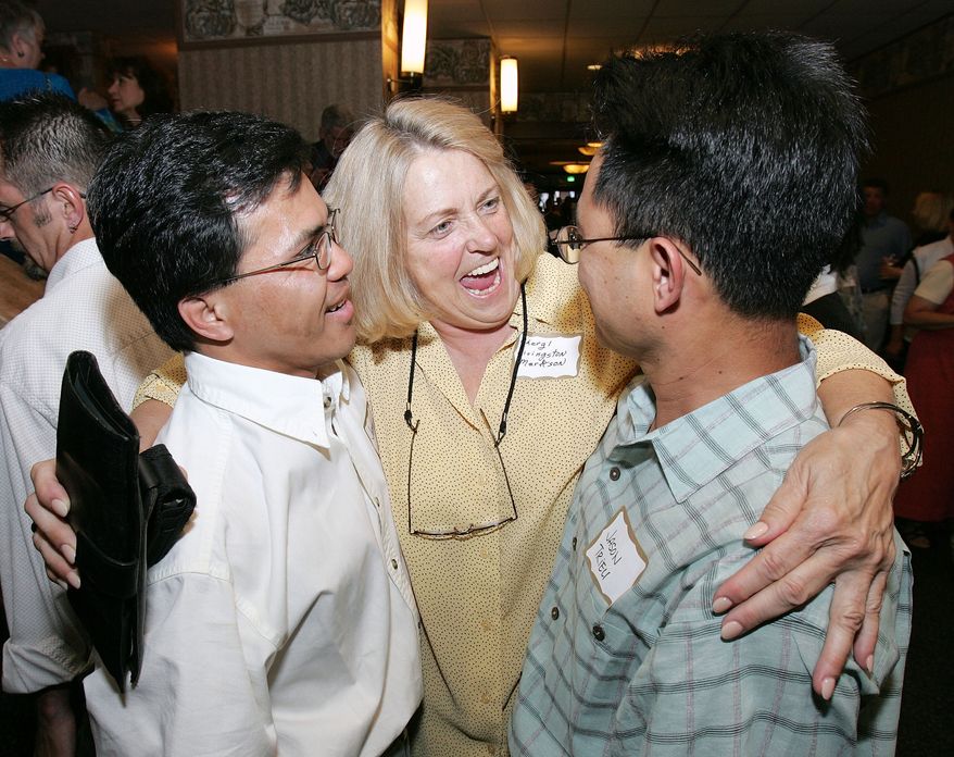 Cheryl Livingston Markson, center, hugs brothers Jason Triew, right, and Jeff Gahr, during a reception for former Operation Babylift orphans in San Francisco, Calif., Sunday, June 12, 2005. Both Triew and Gahr were on the original Operation Babylift World Airways aircraft 30 years ago, but the older brother, Triew, was removed from the aircraft due to his age and wasn&#39;t able to get out of Vietnam for several weeks. Both are returning the Vietnam for the 30th anniversary of the airlift. (AP Photo/Ric Feld)