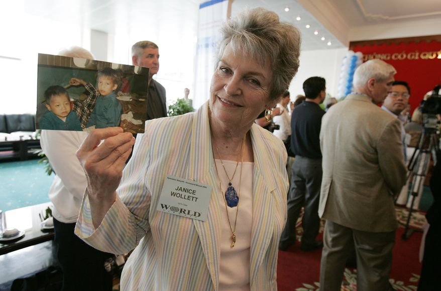 Janice Wollett, a former flight attendant from &quot;Operation Babylift,&quot; holds a picture of Vietnamese orphans she helped to evacuate from Vietnam in April 1975. She arrived aboard the 30th commemoration flight of World Airways at Tan Son Nhut airport in Ho Chi Minh City, formerly Saigon, Vietnam, Wednesday, June 15, 2005. More than 20 Vietnamese orphans adopted 30 years ago during &quot;Operation Babylift&quot; along with members of the original crew returned to Vietnam for the 30th anniversary of the airlift. (AP Photo/Richard Vogel)