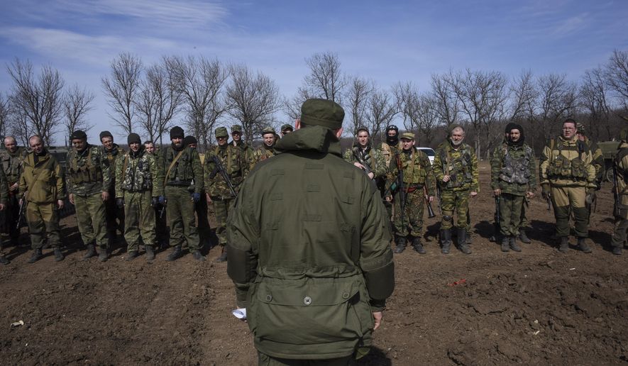 In this Wednesday, March 11, 2015, file photo, pro-Russian rebels line up in front of their commander during a military training exercise near Yenakiyeve, eastern Ukraine. AP reporting, based on dozens of conversations with rebel fighters and visits to their training grounds, has revealed the extent of the involvement of Russian troops in the yearlong conflict. (AP Photo/Mstyslav Chernov, File)