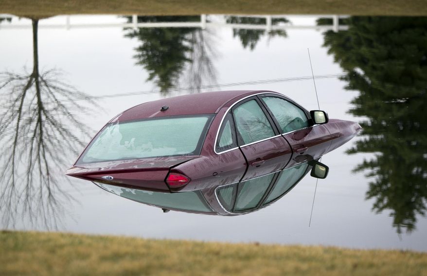 A car floats in a pond on 76th Street, Friday, April 3, 2015, in Caledonia Township, Mich. Authorities said the body of a man was found floating nearby. The man's death is under investigation. (AP Photo/The Grand Rapids Press, Cory Morse) ALL LOCAL TELEVISION OUT; LOCAL TELEVISION INTERNET OUT