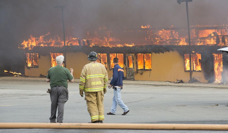 Firefighters work the scene of a fire at Mid-State Lumber in Warwick, N.Y., on Thursday, April 2, 2015. Officials say firefighters from 20 fire departments battled the blaze into Thursday night and Friday morning. At least one building on the property was destroyed. (AP Photo/Times Herald-Record, Robert G Breese)
