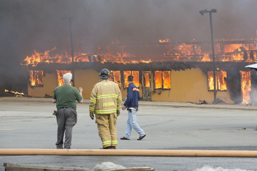 Firefighters work the scene of a fire at Mid-State Lumber in Warwick, N.Y., on Thursday, April 2, 2015. Officials say firefighters from 20 fire departments battled the blaze into Thursday night and Friday morning. At least one building on the property was destroyed. (AP Photo/Times Herald-Record, Robert G Breese)