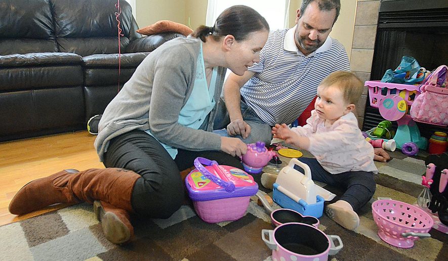 FOR RELEASE SUNDAY, APRIL 5, 2015, AT 12:01 A.M. EDT.-In a March 18, 2015 photo,Samantha Hilton (right) reaches for her mother, Alexis Hilton, as they play at home as her dad, Steve Hilton, watches. Alexis Hilton donated a kidney to her husband. (AP Photo/The Hickory Daily Record, Robert C. Reed)