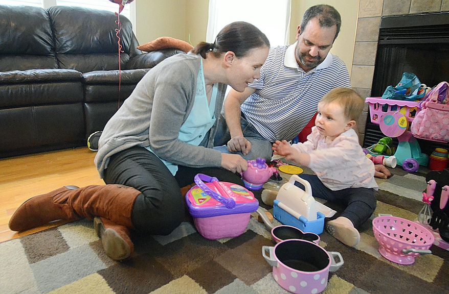 FOR RELEASE SUNDAY, APRIL 5, 2015, AT 12:01 A.M. EDT.-In a March 18, 2015 photo,Samantha Hilton (right) reaches for her mother, Alexis Hilton, as they play at home as her dad, Steve Hilton, watches. Alexis Hilton donated a kidney to her husband. (AP Photo/The Hickory Daily Record, Robert C. Reed)