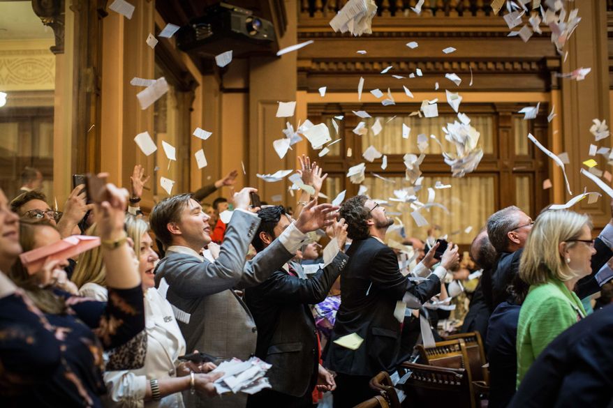 House members throw up paper at the conclusion of the legislative session in the House Chamber, Friday, April 3, 2015, in Atlanta. By law, Georgia's General Assembly meets for 40 working days each year. Any bills not approved by each chamber by midnight are dead for the year. (AP Photo/Branden Camp)