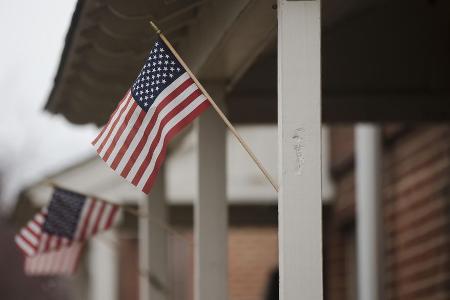 Flags are posted on the home of a woman who is accused of trying to join and martyr herself for the Islamic State group in Syria, Friday, April 3, 2015, in Philadelphia. Thirty-year-old Keonna Thomas appeared in federal court Friday afternoon just hours after her arrest on a charge of attempting to provide material support and resources to a foreign terrorist organization. A prosecutor says a search warrant executed March 27 at Thomas' home prevented her from leaving the U.S. on a flight scheduled for March 29.(AP Photo/Matt Rourke)